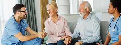 Home Health Software | Two care givers sitting with two people - Netsmart myUnity® home health EHR software for clinical documentation, scheduling, and billing