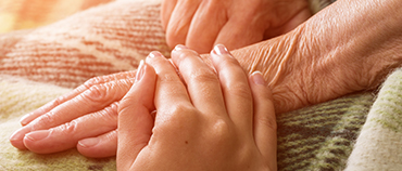 Netsmart Blog Hospice Nurses holding Elderly Patient's Hand