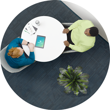View from above of two people at a table - Netsmart addiction treatment solutions support integrated abstinence-based treatment models to effectively address recovery and prevention.